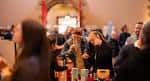 Interior del local durante un evento con personas degustando bebidas y productos