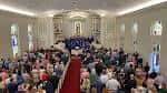 Interior de la iglesia con congregación reunida y coro en el altar