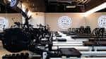 Interior del gimnasio STRONG Pilates con máquinas de pilates y logotipos circulares en la pared