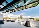 Vista panorámica de la terraza Spy Hop Rooftop con mesas y sillas dispuestas para eventos