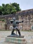 Estátua de Robin Hood frente a una pared histórica
