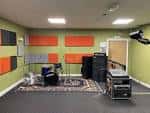 Sala de ensayo con equipo musical y paneles acústicos