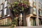 Fachada exterior del hotel The BoTree con diseño moderno y vegetación colgante