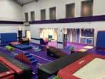 Interior del centro comunitario con colchonetas y obstáculos para clases de gimnasia