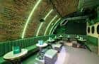 Interior del espacio DUO Clapham con iluminación verde y mesas dispuestas
