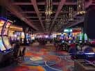 Piso principal del casino con máquinas tragaperras y zona de juegos iluminada