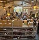 Interior del local con estanterías de vinos y clientes