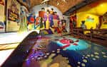 Interior del museo con exhibición interactiva iluminada y maniquíes de los Beatles