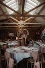 Salón interior decorado para recepción de boda con mesas redondas y iluminación cálida