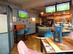 Vista del interior del pub con mesas y sillas de colores