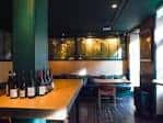 Área interior con botellas de vino sobre mostrador y decoración verde