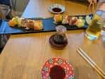 Mesa con platos de tapas japonesas y bebidas en el interior del restaurante