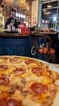 Plano cercano de una pizza con pepperoni servida en el local