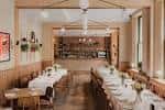 Interior del pub The Greyhound con mesas dispuestas para eventos y barra al fondo