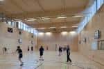 Interior del gimnasio con personas jugando baloncesto
