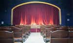 Interior del auditorio del Ruba Club con cortinas rojas y butacas dispuestas para eventos