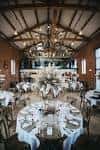 Interior del salón de eventos con mesas redondas decoradas para una boda
