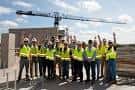Equipo de construcción en una obra con grúa al fondo