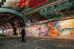 Interior del túnel con grafitis coloridos y una persona caminando