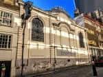 Fachada lateral de la iglesia con detalles arquitectónicos y ventanales góticos