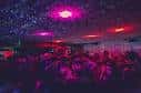 Interior del club Queen of Hoxton con iluminación de discoteca y público