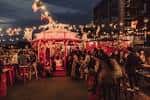 Atardecer en el rooftop del Queen of Hoxton con iluminación cálida y ambiente festivo
