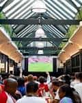Evento deportivo en el BOXHALL City con pantalla gigante y público reunido