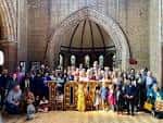 Interior de la iglesia con grupo de personas reunidas frente al altar, mostrando el espacio disponible para eventos