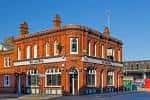 Fachada exterior del pub The Anchor en Digbeth, Birmingham, con arquitectura de ladrillo rojo y cielo despejado
