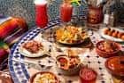 Mesa con tapas cubanas y cócteles servidos en el restaurante
