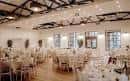 Sala de eventos preparada para una boda con mesas y sillas decoradas
