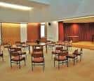Sala de reuniones con sillas dispuestas en círculo y escenario al fondo