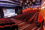 Amplo auditorio con butacas rojas dispuestas en filas hacia el escenario