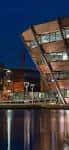 Fachada exterior moderna del Nottingham Wildcats Arena al atardecer con reflejos en el agua