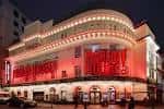 Fachada exterior del Piccadilly Theatre iluminado por la noche en Londres