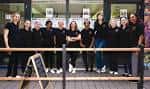 Equipo del centro de terapia posando frente a la entrada