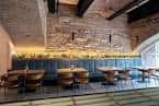 Zona de comedor con mesas redondas y paredes de piedra
