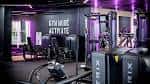 Gimnasio moderno con equipamiento deportivo e iluminación morada