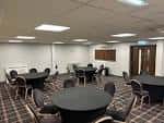 Sala de conferencias interior con mesas redondas y sillas dispuestas para un evento