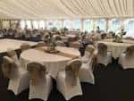 Salón de eventos decorado con mesas redondas y mantelería blanca, ideal para bodas o celebraciones