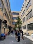 Patio exterior del edificio The Stutz con personas reunidas bajo cielo despejado