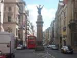 Vista de la calle Fleet Street con el monumento del Temple Bar y un autobús rojo en Londres