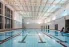 Piscina interior con carriles y estructura de techo alto
