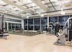 Gimnasio interior con equipamiento deportivo y grandes ventanales
