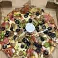 Pizza familiar con múltiples ingredientes como aceitunas, pimientos y pepperoni
