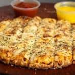 Pizza de borde relleno con queso y salsa de tomate al lado