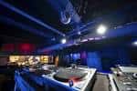 Interior del People's Leisure Club con cabina de DJ e iluminación azul