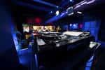 Vista interior del club nocturno con equipo de DJ y ambiente oscuro