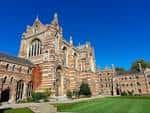 Fachada principal del edificio de Keble College bajo cielo azul despejado