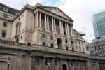Vista lateral del edificio del Banco de Inglaterra con columnas clásicas y rascacielos modernos al fondo